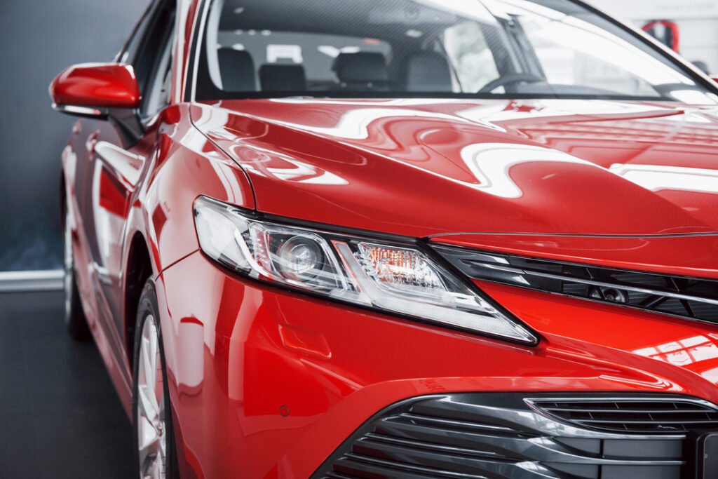 Headlights of the new red car, in the car dealership